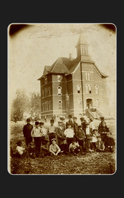 Picture of the school with Children in front of it.